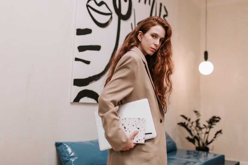 Woman in Brown Coat Holding Laptop Computer